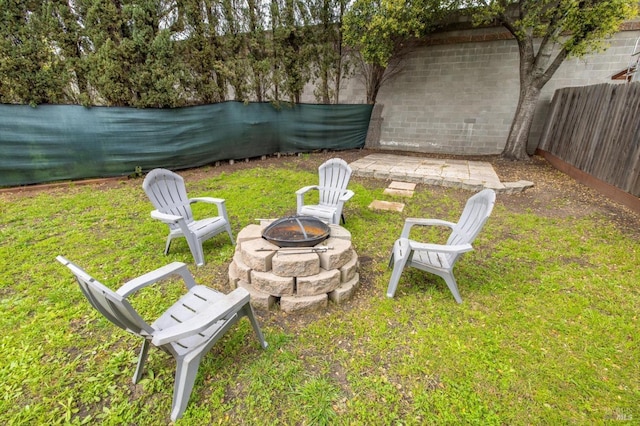 view of yard with a fenced backyard and a fire pit