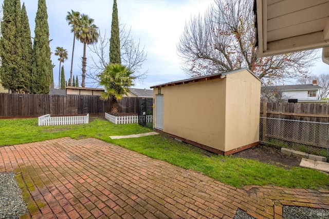 view of patio / terrace with an outbuilding, a fenced backyard, and a shed