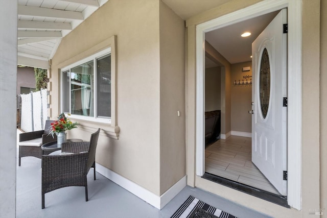 property entrance featuring covered porch and stucco siding