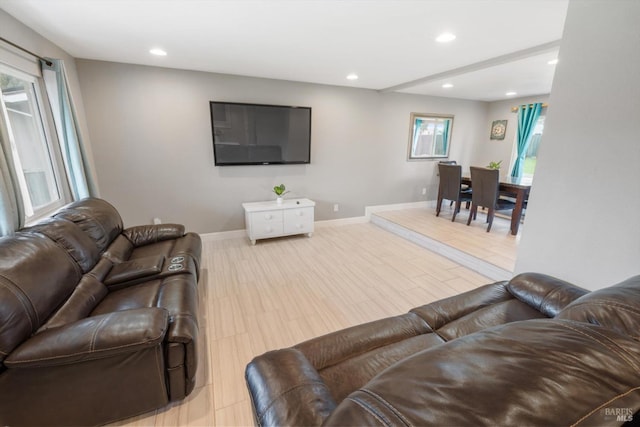 living area featuring a wealth of natural light, wood finished floors, baseboards, and recessed lighting