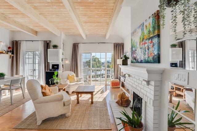 living area featuring wood ceiling, a brick fireplace, beam ceiling, and wood finished floors