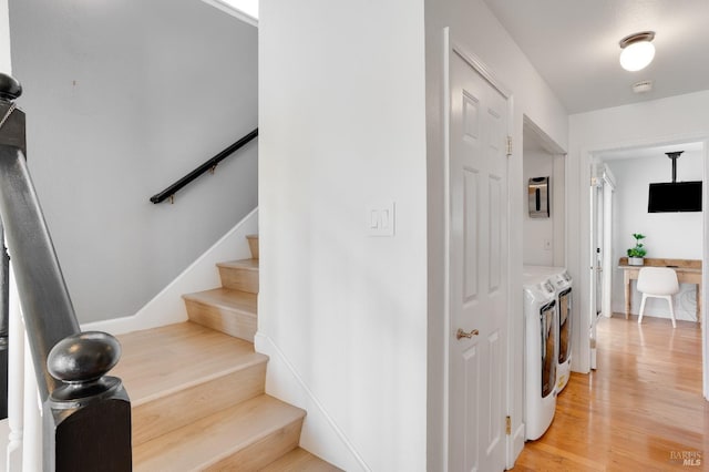 stairs featuring washing machine and clothes dryer and wood finished floors