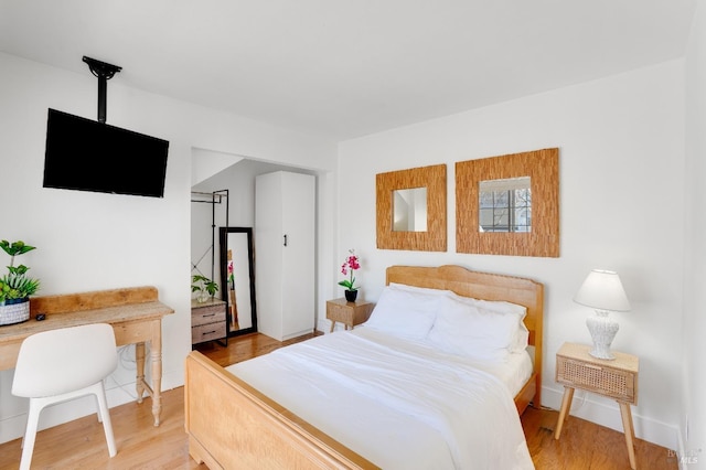 bedroom featuring light wood-type flooring and baseboards