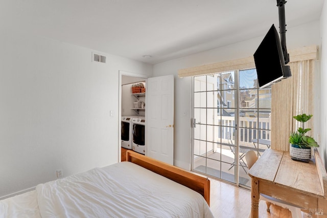 bedroom with access to outside, visible vents, washer and clothes dryer, and wood finished floors