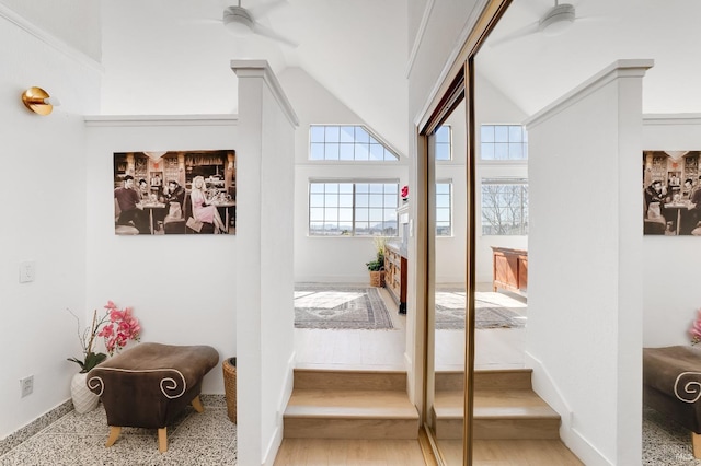 entryway featuring a ceiling fan, lofted ceiling, baseboards, and wood finished floors