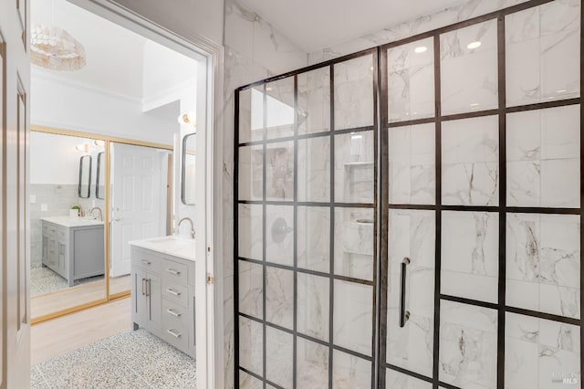 full bath featuring a stall shower, vanity, and tile walls