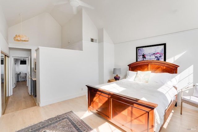 bedroom with high vaulted ceiling, light wood-type flooring, visible vents, and baseboards