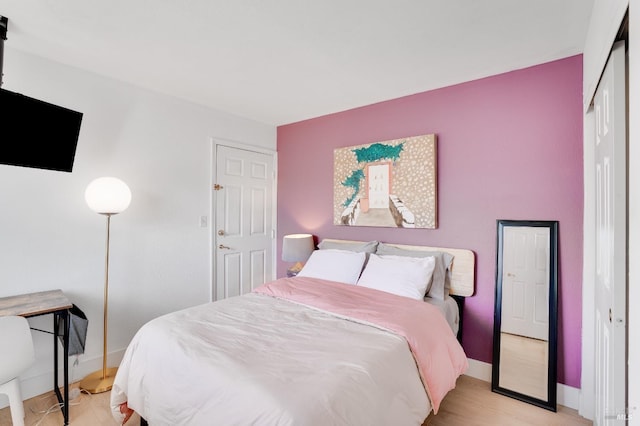 bedroom with light wood-style floors and baseboards