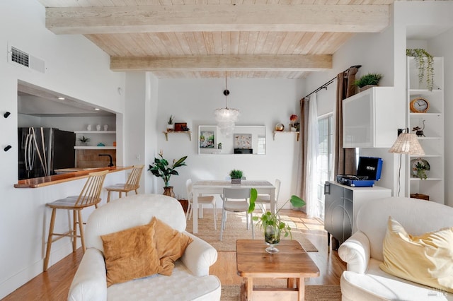 living area featuring light wood finished floors, visible vents, baseboards, wood ceiling, and beam ceiling