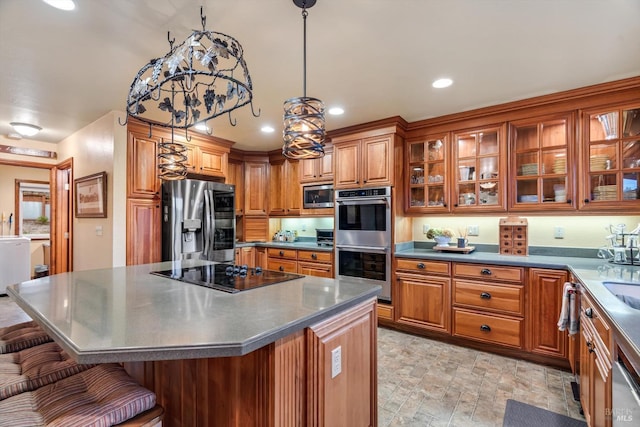 kitchen with recessed lighting, stainless steel appliances, a center island, brown cabinetry, and a kitchen bar