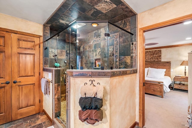 ensuite bathroom with a shower stall, ornamental molding, stone tile floors, and connected bathroom