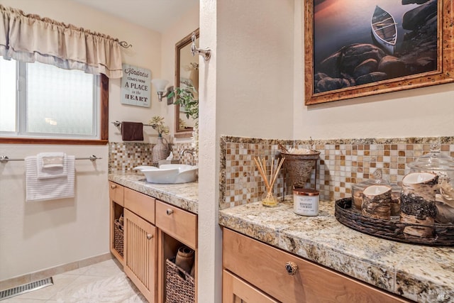 bathroom featuring visible vents, decorative backsplash, vanity, tile patterned flooring, and baseboards