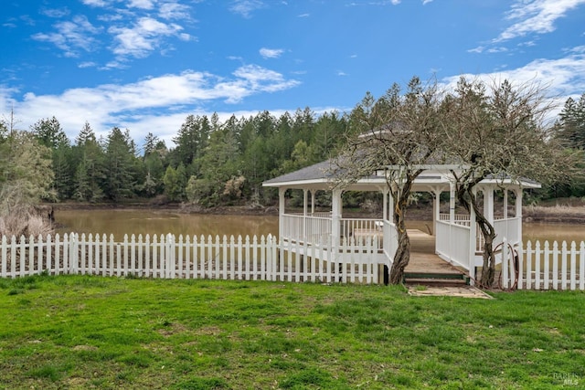 view of yard featuring a water view, fence, and a gazebo