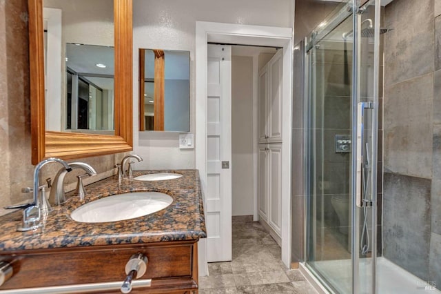 bathroom with double vanity, a stall shower, and a sink