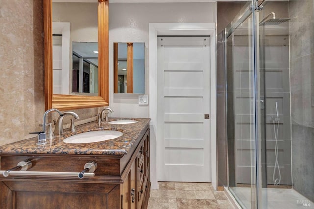 full bath featuring a sink, a stall shower, and double vanity