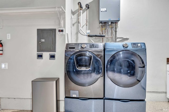 laundry room featuring electric panel, tankless water heater, separate washer and dryer, and laundry area