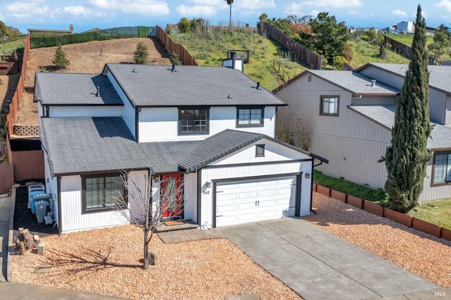 modern farmhouse style home with fence, concrete driveway, roof with shingles, a chimney, and a garage