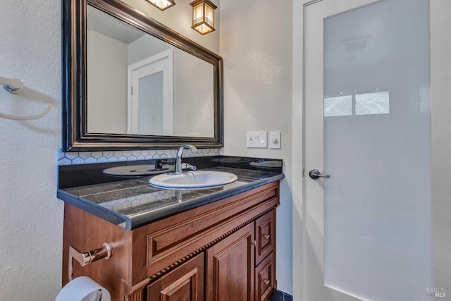 bathroom featuring vanity and a textured wall