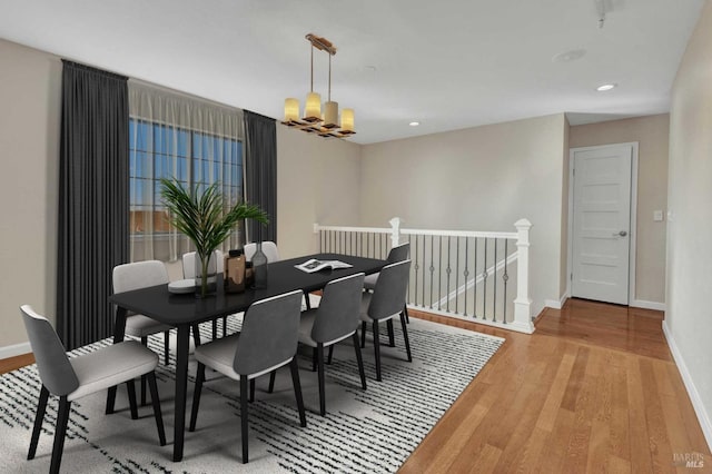 dining space featuring recessed lighting, a notable chandelier, wood finished floors, and baseboards