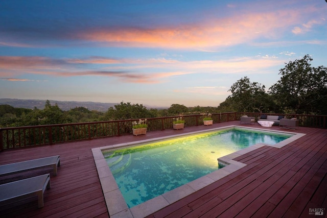 view of pool with a fenced in pool, an outdoor living space, and a wooden deck