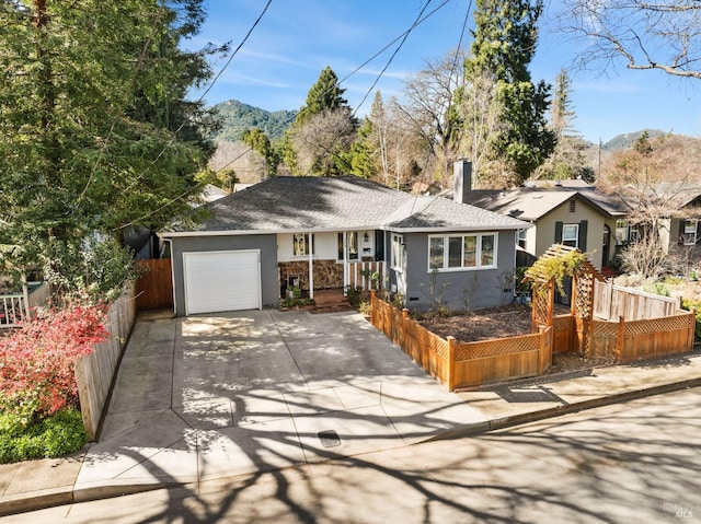 ranch-style home with a garage, driveway, fence, and stucco siding