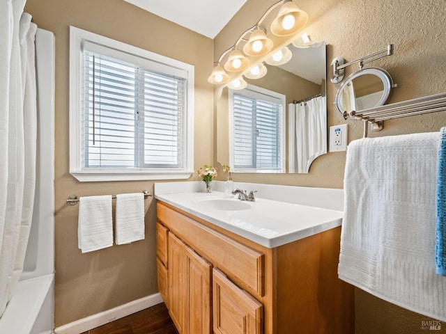 bathroom featuring baseboards, wood finished floors, and vanity