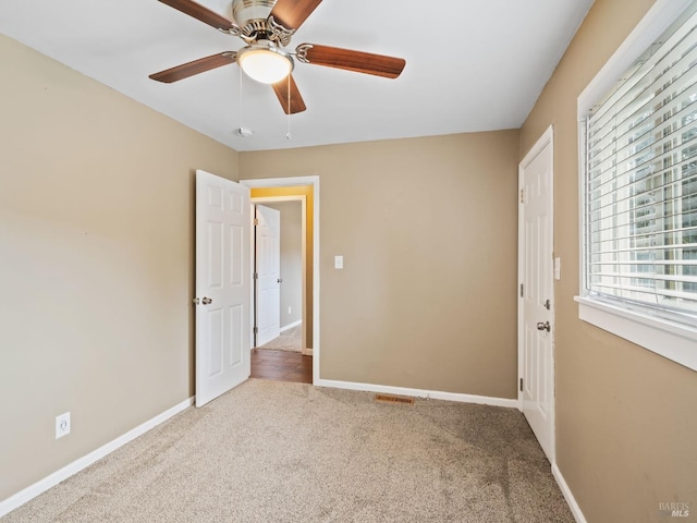 unfurnished bedroom featuring carpet, ceiling fan, and baseboards