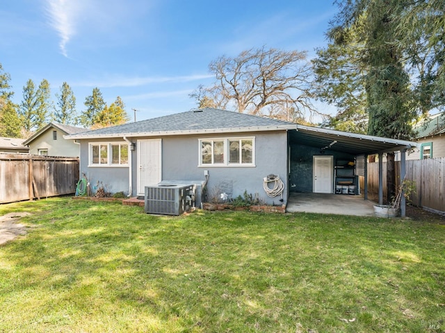 back of house featuring a yard, stucco siding, a patio area, central AC, and a fenced backyard