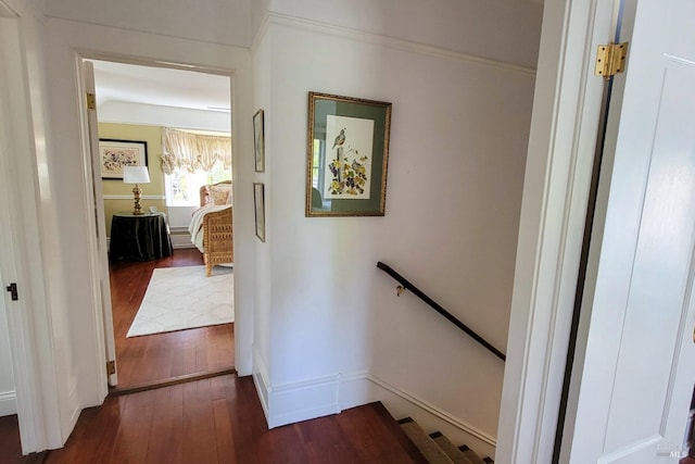 hallway featuring dark wood-style floors, an upstairs landing, and baseboards