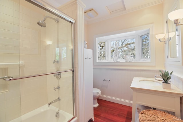 bathroom featuring toilet, shower / bath combination with glass door, wood finished floors, crown molding, and vanity