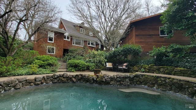 rear view of house featuring a patio, an outdoor fire pit, and a chimney