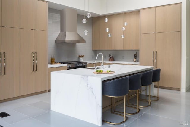 kitchen featuring wall chimney exhaust hood, stainless steel gas range oven, modern cabinets, and a sink