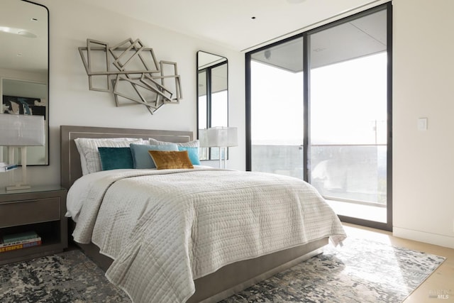 bedroom with access to outside and a wall of windows