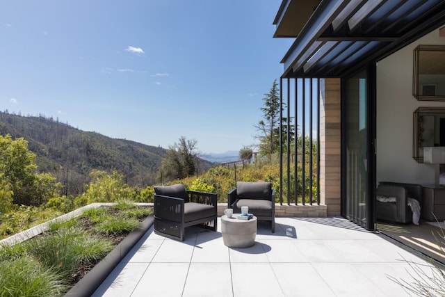 view of patio featuring a mountain view and a forest view