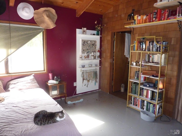 bedroom featuring vaulted ceiling, wood ceiling, and finished concrete floors