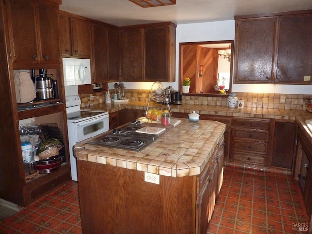 kitchen with a center island, white appliances, tile countertops, and decorative backsplash