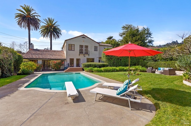 pool featuring a patio area, a lawn, outdoor lounge area, and a diving board