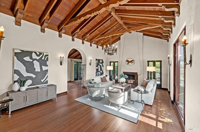 living room with arched walkways, a large fireplace, wooden ceiling, and wood finished floors