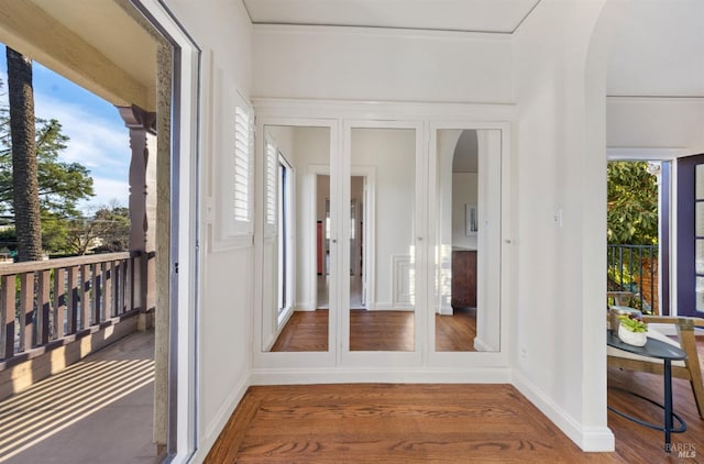 sunroom / solarium featuring arched walkways and plenty of natural light