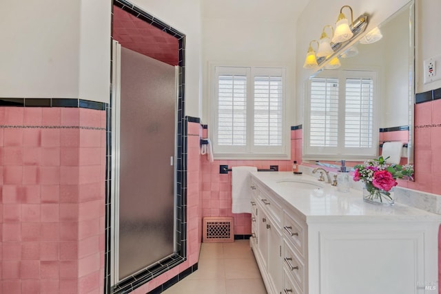 bathroom with visible vents, tile patterned flooring, vanity, a shower stall, and tile walls