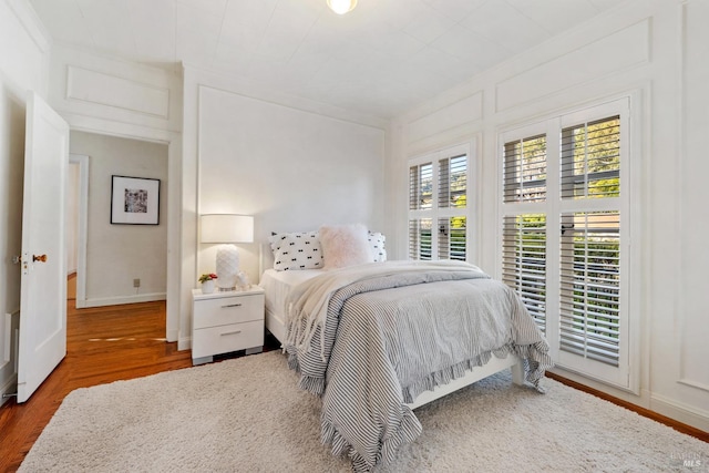 bedroom featuring baseboards and wood finished floors