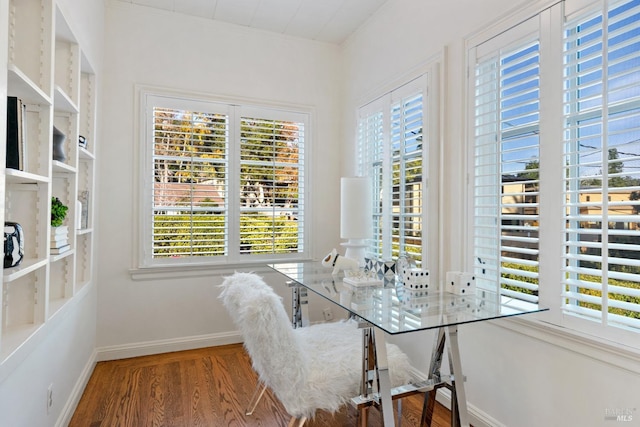 dining space featuring baseboards and wood finished floors