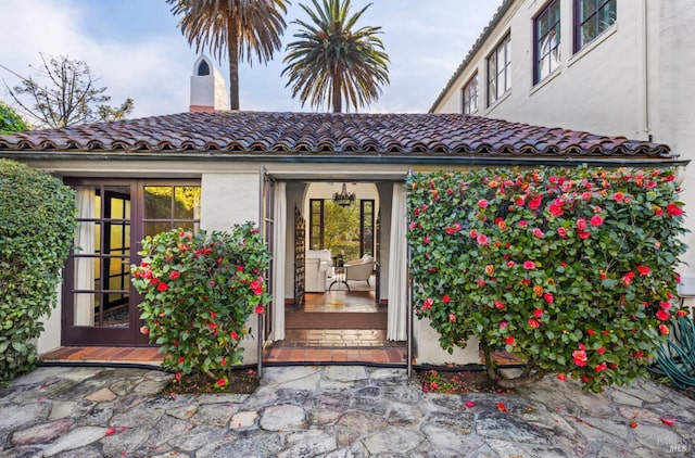 view of exterior entry featuring french doors and stucco siding