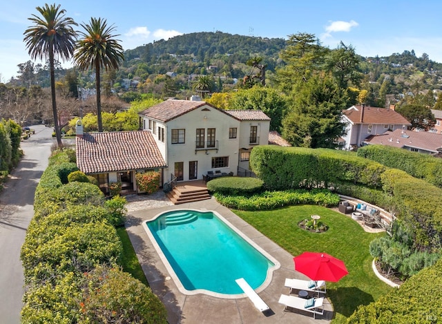 pool featuring a patio area, a yard, and a diving board