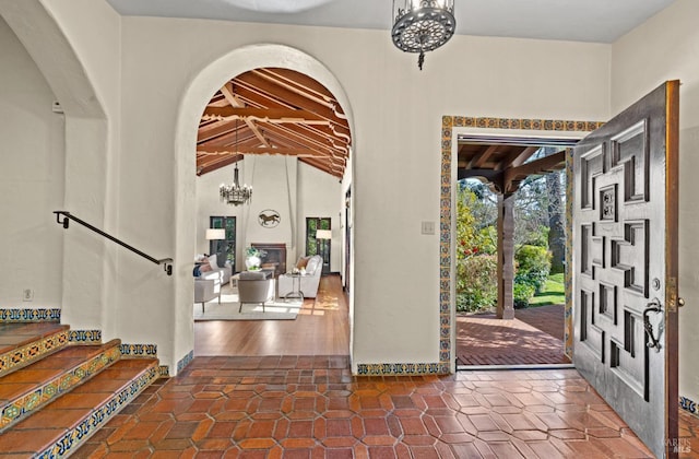 tiled foyer with stairway and an inviting chandelier