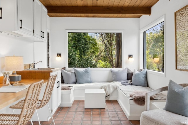 sunroom / solarium featuring wood ceiling, a sink, and beam ceiling