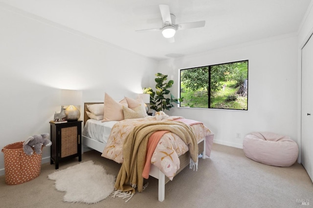 carpeted bedroom featuring ceiling fan, baseboards, and crown molding