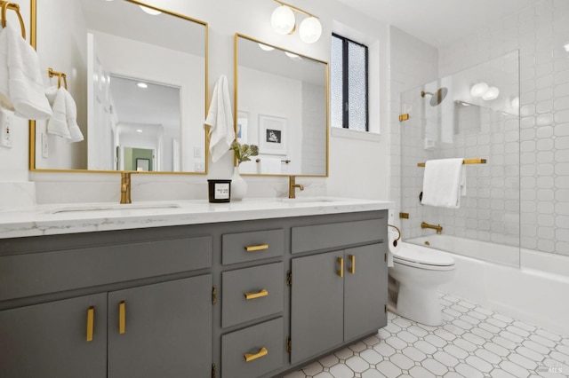 bathroom featuring a sink, shower / bathing tub combination, toilet, and double vanity