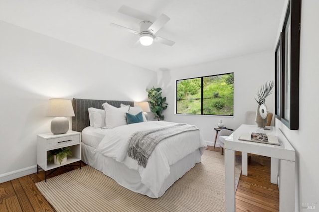 bedroom featuring a ceiling fan, baseboards, and wood finished floors