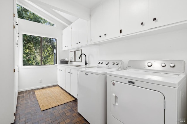 laundry area featuring separate washer and dryer, a sink, cabinet space, and baseboards